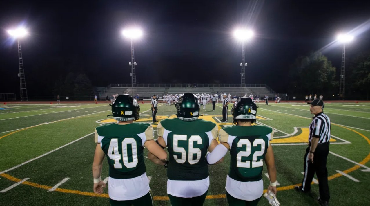 Football players on the field under the stadium lights