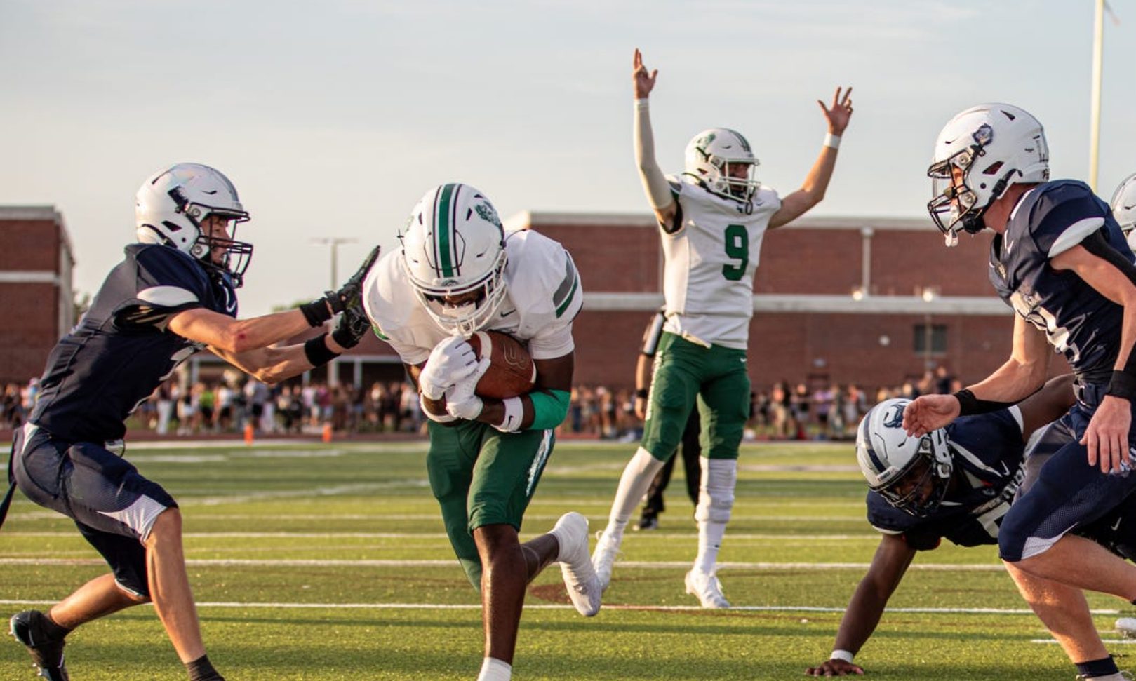 High school football player scoring a touchdown as a teammate celebrates